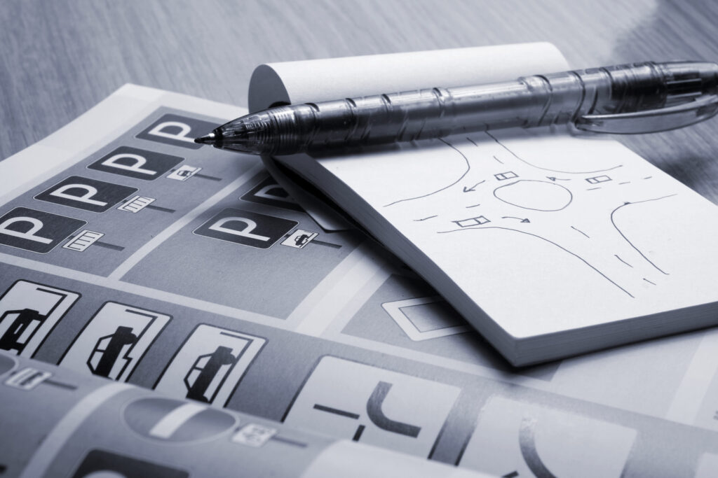 Notepad,,Book,Of,Traffic,Rules,And,Pen,On,A,Desk